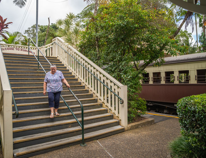 A customer navigates the flight of 31 stairs to access Kuranda railway station